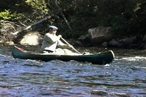 he descends the rapids in a canoe