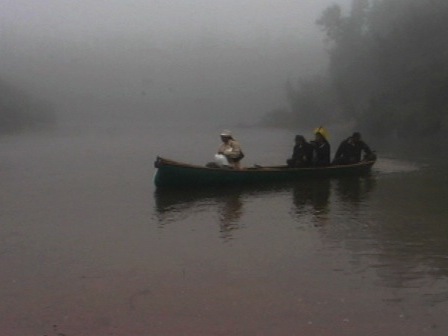 Un Innu et trois Kayapos en canot sur la rivière Mingan