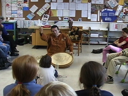 Paul-Émile Dominique explique le tambour traditionnel à des jeunes