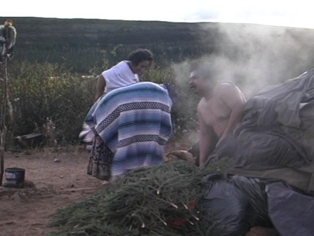 A small group of people exit a sweat lodge