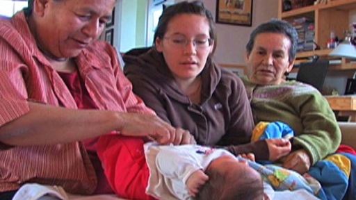 Grandmother, mother and aunt gathered around a newborn infant