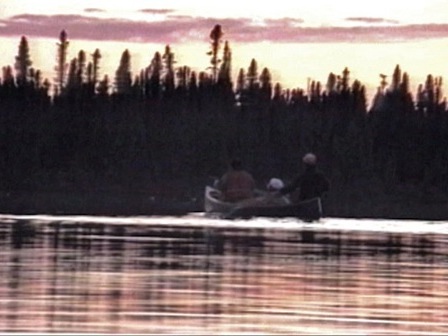 A man and woman in a canoe at sunset