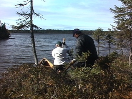 Two hunters prepare to launch their canoe