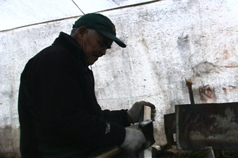 he splits wood chips with an axe