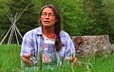 Woman sitting on the ground in a field near Kahnawake, Quebec