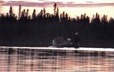 A man and woman in a canoe at sunset