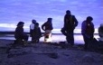 A group of Innu rests by a fire in the early morning