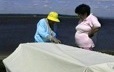 Deux femmes innues prennent la mesure d'une toile pour en faire une tente