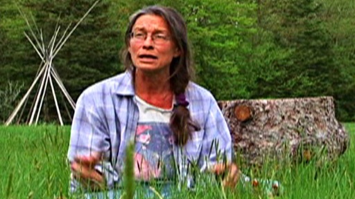 Woman sitting on the ground in a field near Kahnawake, Quebec