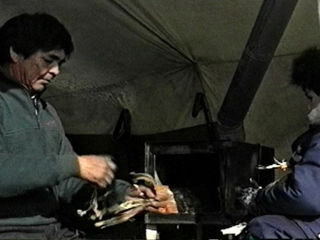 Zacharie Bellefleur teaches Messenak Bellefleur to start a fire in the tent stove